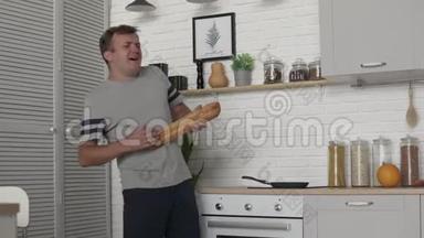 一个男人早上在厨房里用一条白绒布跳舞唱歌。